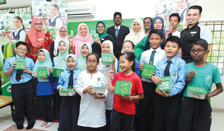 ILIANI (belakang empat kiri) dan Mahenderan (berkot) bersama pelajar Sekolah Kebangsaan Bukit Bandaraya dengan pek MILO masing-masing.
