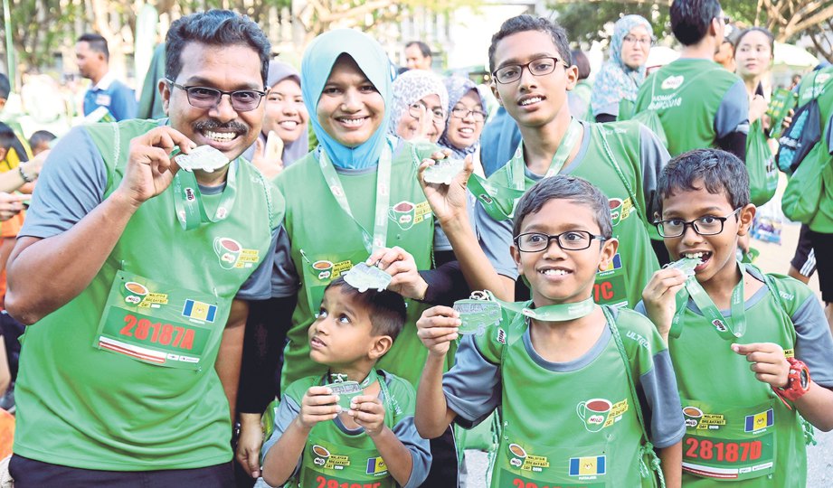 PESERTA bersama medal larian Hari Sarapan Malaysia Milo.