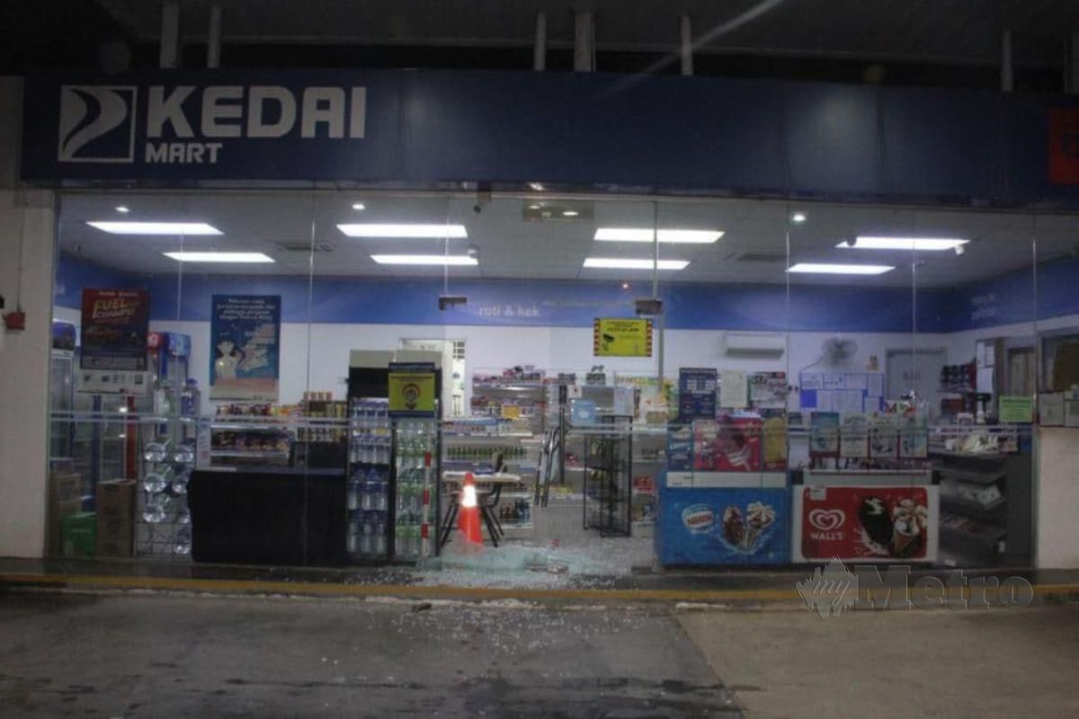 SUSPEK memecahkan cermin stesen minyak sebelum dia ditahan di dalam premis itu di Batu 2, Jalan Seremban-Port Dickson, pagi semalam. FOTO ihsan polis. 