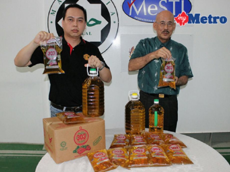  Gan (kanan) bersama pekerjanya menunjukkan minyak masak yang masih mencukupi untuk dijual kepada pembekal dan orang ramai. FOTO Nik Abdullah Nik Omar
