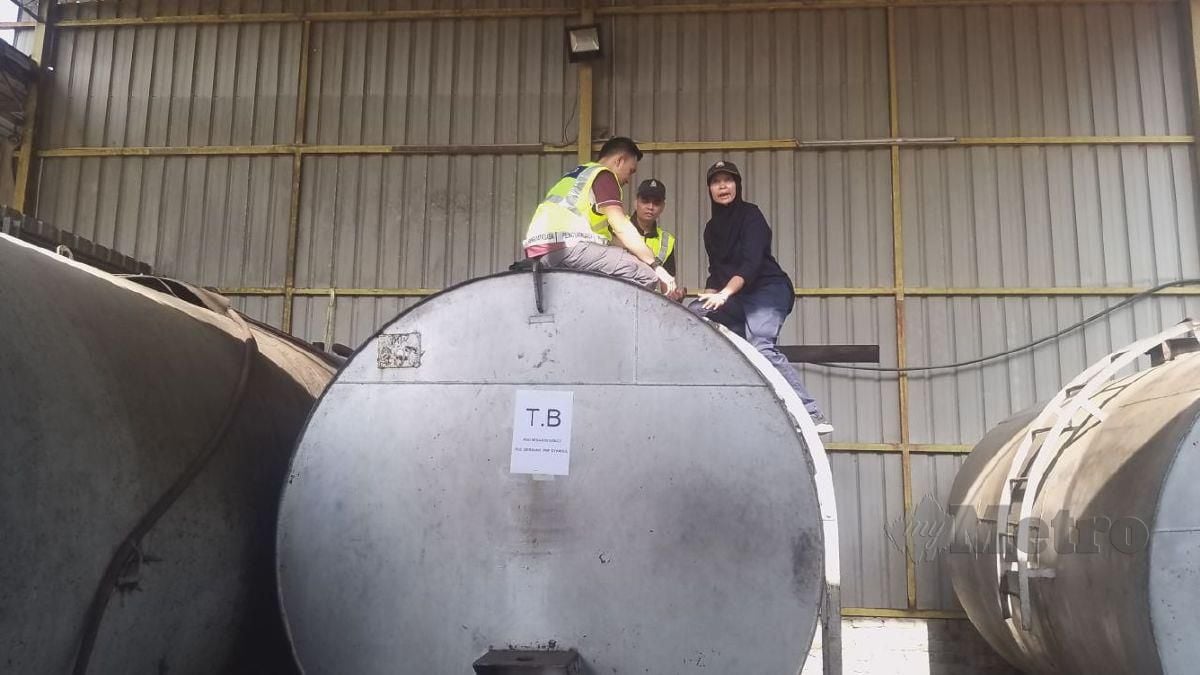 Farah Adlina dan penguatkuasa KPDN Perlis sedang meneliti bekalan diesel yang dirampas dan masih terdapat dalam tangki penyimpanan di sebuah stor pemborong diesel di Kawasan Perindustrian Padang Besar. FOTO AIZAT SHARIF