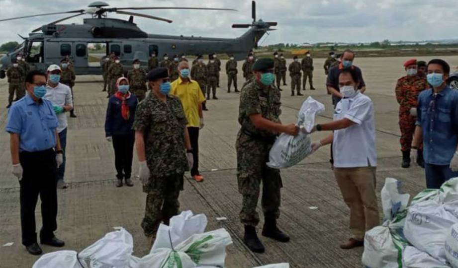 ABANG Johari (dua kiri) menyaksikan penyerahan bekalan makanan kepada Lt Jen Datuk Zamrose pada pelancaran penghantaran makanan ke kawasan pedalaman Sarawak, hari ini. FOTO ATM