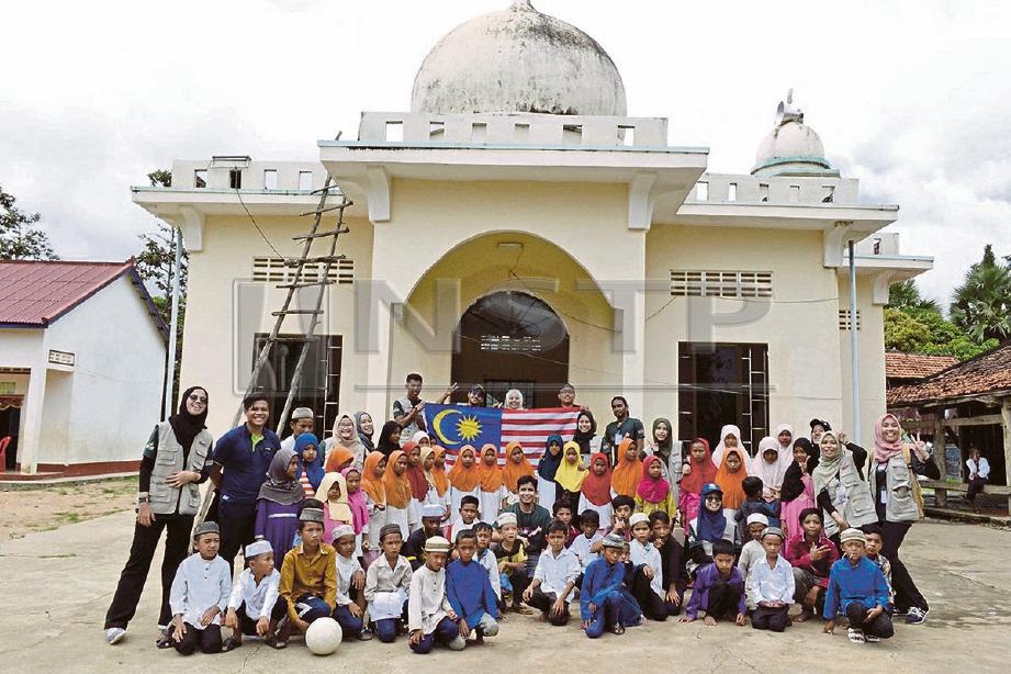 SUKARELAWAN HUMIC 2018 dan sebahagian penduduk kanak-kanak bergambar kenangan di hadapan masjid.