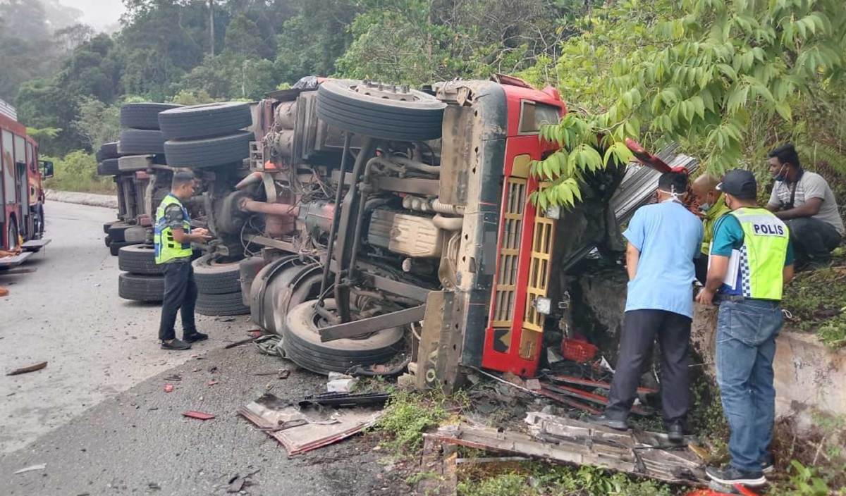 PEMANDU dan kelendan maut apabila lori treler dengan muatan besi terbabas di Kilometer 55, Jalan Lipis – Merapoh (Jalan Lama) hari ini. FOTO Ihsan PDRM