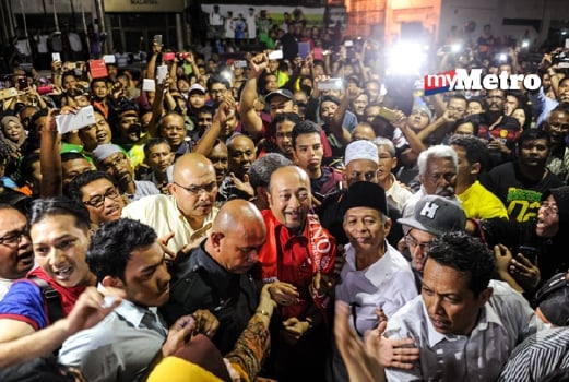 Mukhriz (tengah) disambut penyokongnya ketika hadir di hadapan Bangunan Tunku malam ini. - Foto BERNAMA
