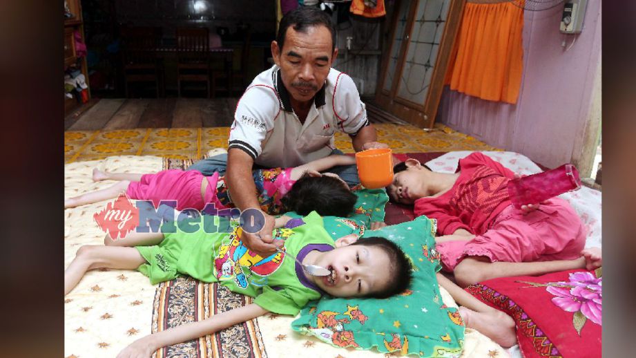 Mohd Zain tabah menjaga tiga anaknya yang menghidapi CP ketika ditemui di rumahnya di Kampung Kok Keli 1, Tumpat. FOTO  Faris Zainuldin