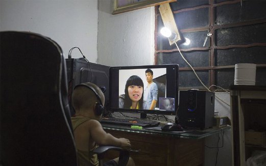 XIAO Le, lima tahun, membuat panggilan video dengan ibu bapanya yang bekerja jauh di wilayah Zhejiang.