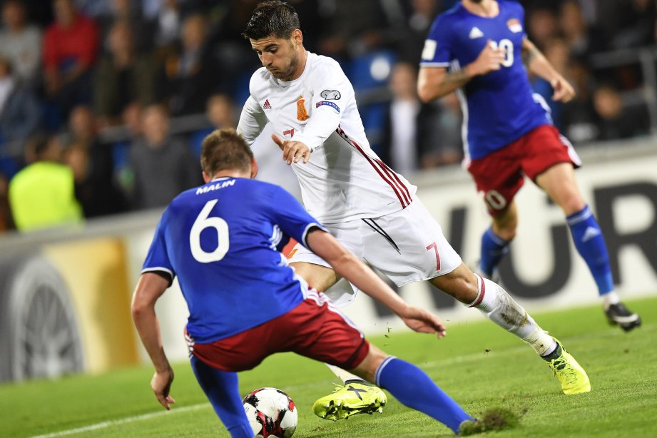  Morata (tengah) cuba melepasi kawalan pemain Liechtenstein. -Foto EPA