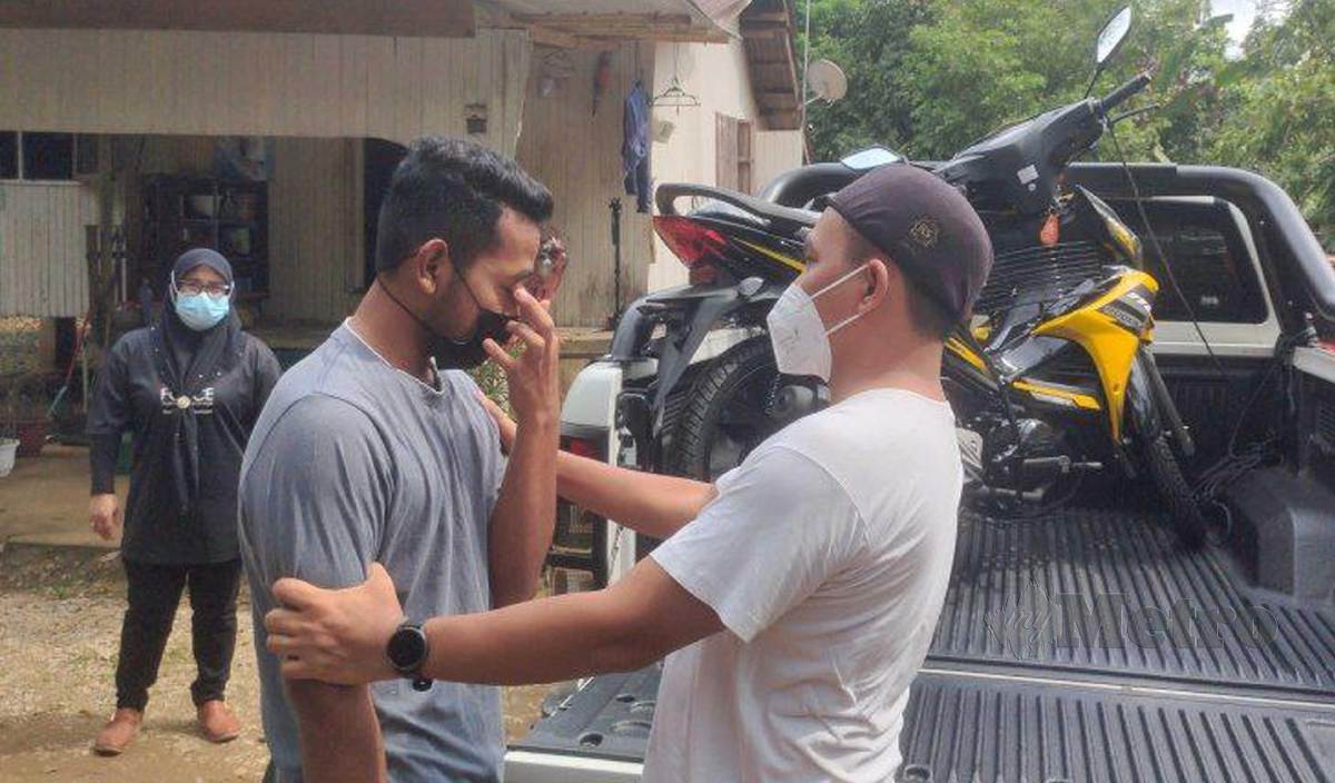MUHAMMAD Hakimi (kiri) menitiskna air mata kesyukuran selepas menerima sumbangan motosikal ketika ditemui di rumahnya Kampung Tok Pelanduk. FOTO Syaherah Mustafa