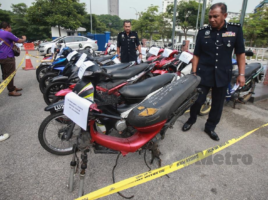 BAHARUDIN (kanan) meninjau motosikal curi yang dirampas menerusi Ops Lejang di Ibu Pejabat Polis Daerah Shah Alam, hari ini. FOTO Sairien Nafis.