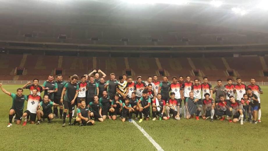 PEMAIN SRT FC (jersi hitam dan hijau) bergambar kenangan dengan pasukan Pescao Rosar di Stadium Shah Alam, malam ini. — FOTO Saiful Affendy Sapran