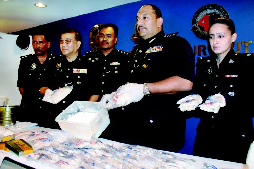 Mior  (dua dari kanan) bersama pegawainya menunjukkan dadah  yang dirampas dalam dua serbuan di Jalan Bukit Gambir dan Jalan Datuk Keramat  di Ibu Pejabat Polis Daerah Timur Laut, Pulau Pinang, semalam.