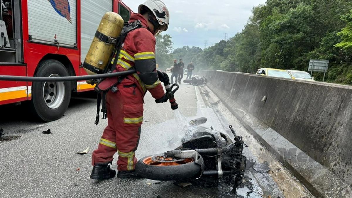 ANGGOTA bomba memadamkan kebakaran sebuah motosikal jenis Honda dalam kemalangan di KM 26.5 Lebuhraya Kuala Lumpur-Karak, dekat Gombak, hari ini. FOTO Ihsan Bomba.