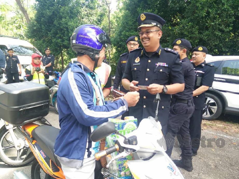 PENGARAH Jabatan Pengangkutan Jalan (JPJ) Melaka, Muhammad Firdaus Shariff (kanan) memeriksa lesen penunggang motosikal pada Ops Motosikal sempena Tahun Baharu Cina di Jalan Ayer Keroh Lama, Melaka. FOTO AMIR MAMAT