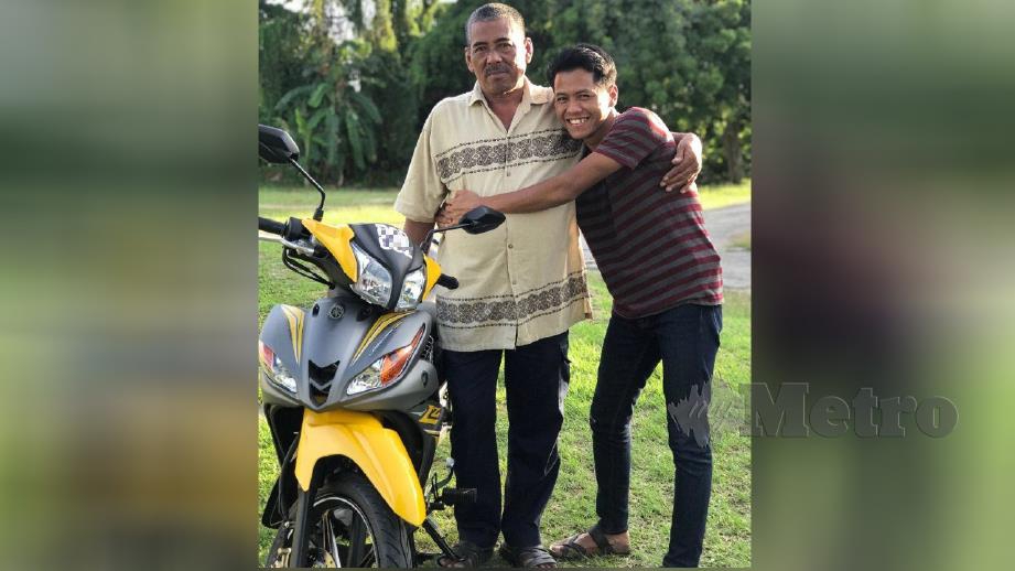 MUHAMMAD Faez memeluk Razali selepas menghadiahkan motosikal sempena hari lahir ayahnya. 