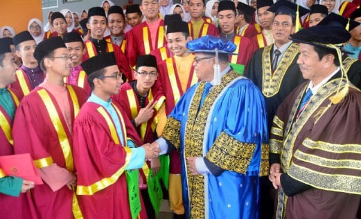 DR Kamarudin mengucapkan tahniah kepada seorang pelajar MRSM Kubang Pasu yang menerima anugerah.