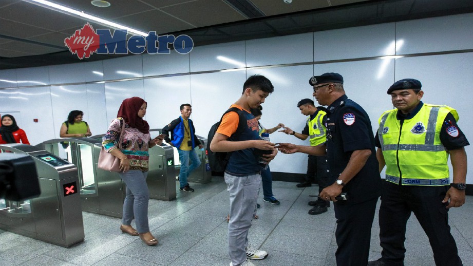 ANGGOTA polis bantuan Prasarana memeriksa kad konsesi MyRapid milik penumpang dalam operasi di Stesen MRT Muzium Negara, Kuala Lumpur, hari ini. FOTO Asyraf Hamzah