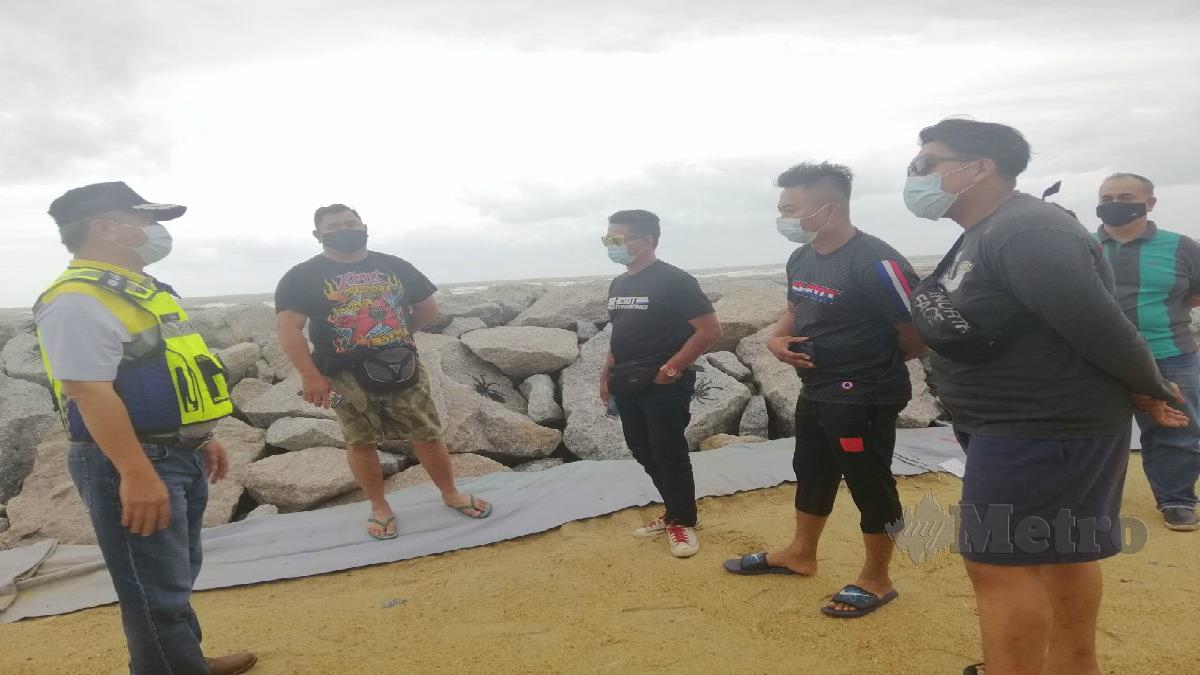 KETUA Polis Daerah Kuala Terengganu, Asisten Komisioner Abdul Rahim Md Din (kiri) menasihatkan pengunjung yang berada di kawasan pantai. FOTO ZATUL IFFAH ZOLKIPLY