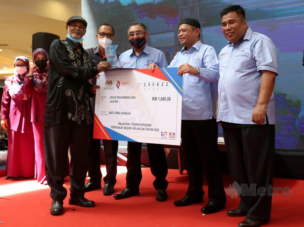 MUSLIMIN  (tengah) bersama  Saiful Adli  (dua dari kanan) menyampaikan Anugerah Tokoh Koperasi kepada Mohamad Jaafar selepas  perasmian Hari Koperasi Negara 2022 Peringkat Negeri Kelantan.