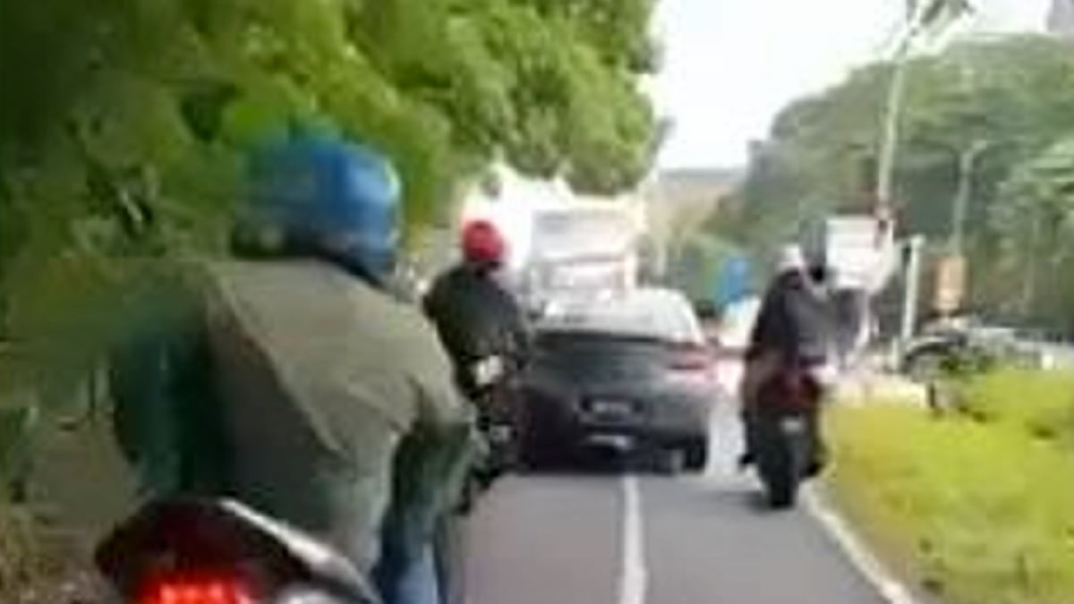 TANGKAP layar daripada video menunjukkan Proton Persona di laluan motosikal Lebuhraya Persekutuan. 