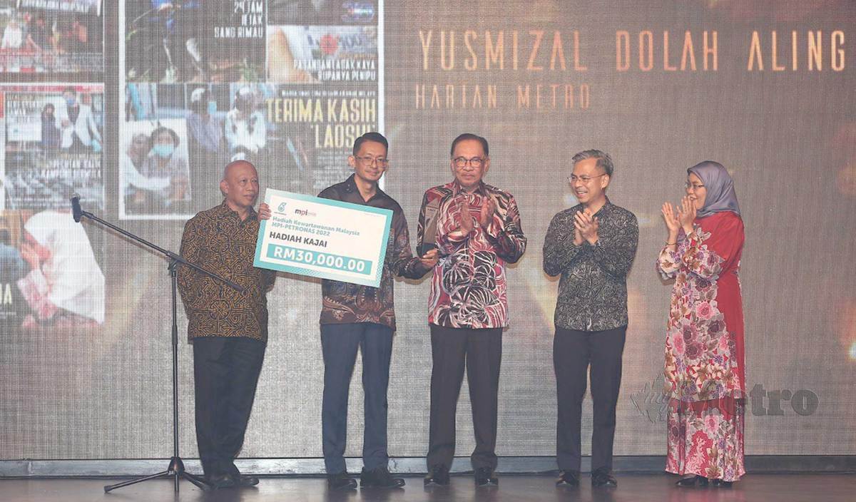 ANWAR menyampaikan anugerah kepada Yusmizal yang dinobatkan pemenang Hadiah Kajai pada Hadiah Kewartawanan Malaysia-MPI Petronas 2022. FOTO Saifullizan Tamadi