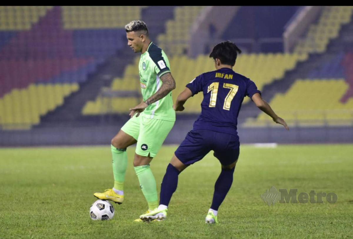 Penjaring penalti Melaka United, Alex Goncalves (kiri) mengatasi kawalan pemain KL City Muhammad Irfan Zakaria (hitam)