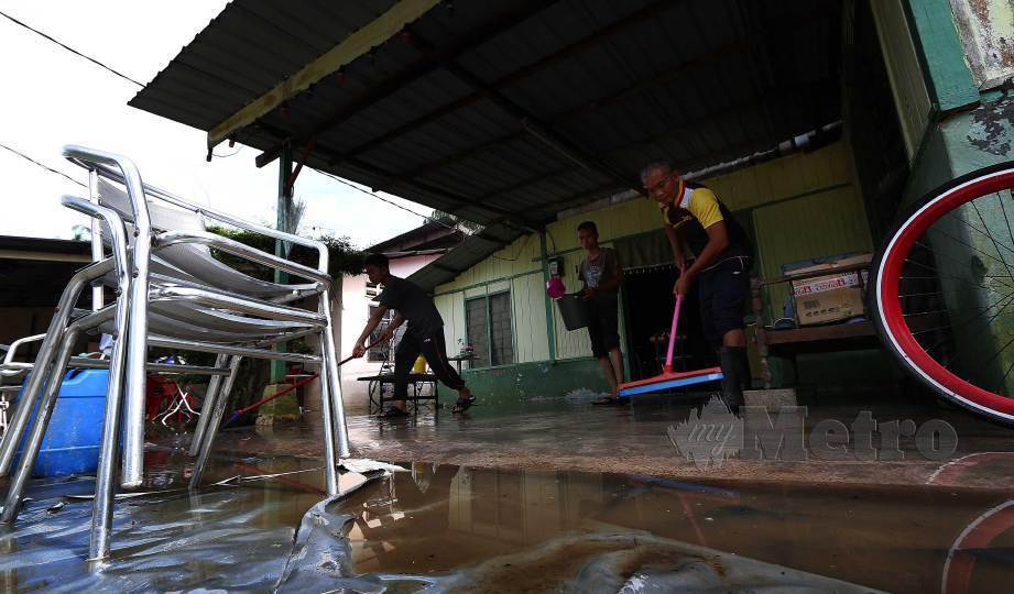 PENDUDUK membersihkan rumah yang terjejas akibat banjir  di Kampung Sabak Aur, Muar. FOTO Iqmal Haqim Rosman
