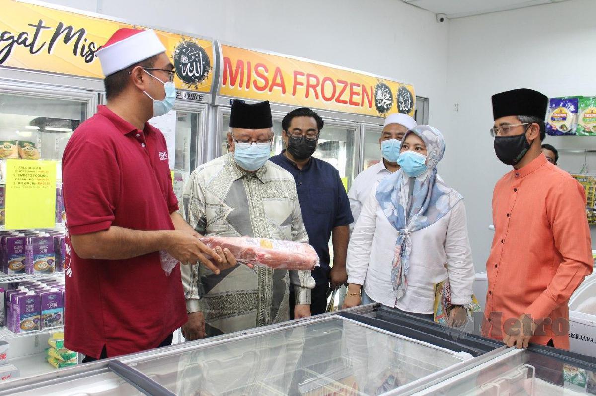 MOHD Yusof  (dua dari kiri) diberi penerangan oleh Mohd Shuhalmi (kiri) mengenai barangan sejuk beku sambil disaksikan Mohd Zaidi selepas merasmikan Misa Frozen di Seremban 2. FOTO Mohd Amin Jalil.