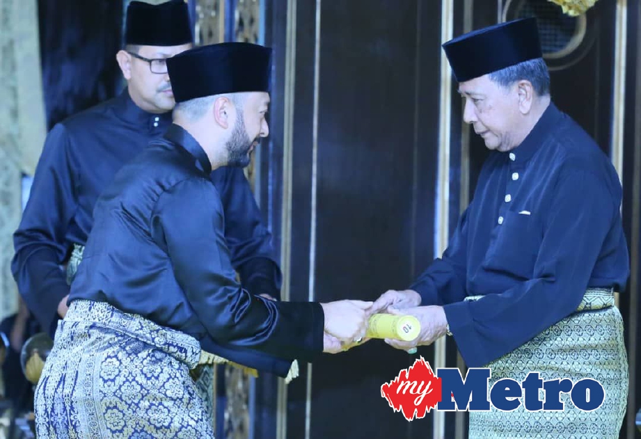 SULTAN Sallehuddin (kanan) menganugerahkan watikah pelantikan jawatan Menteri Besar Kedah yang ke-13 kepada  Mukhriz Mahathir di Istana Anak Bukit. -Foto AMRAN HAMID