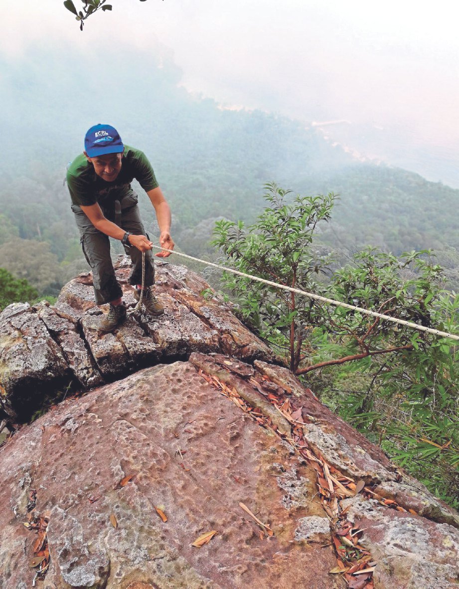 IDROS menggunakan tali keselamatan ketika memanjat bongkah batu ketika mendaki Gunung Nenek Semukut.