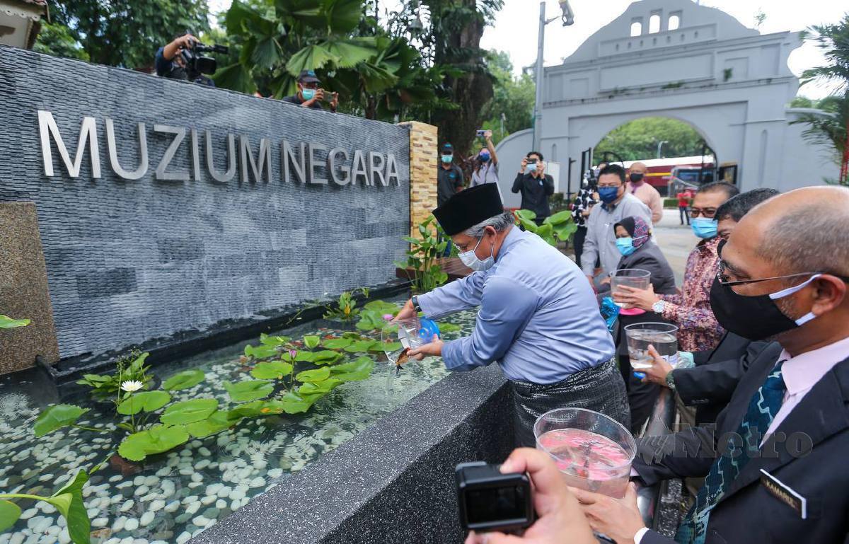 DR Noor Zari (kiri) dan diiringi Ketua Pengarah Jabatan Muzium Malaysia, Datuk Kamarul Baharin A Kasim (kanan) melakukan gimik melepaskan ikan ketika lawatan persiapan pembukaan semula Muzium Negara. FOTO Aswadi Alias
