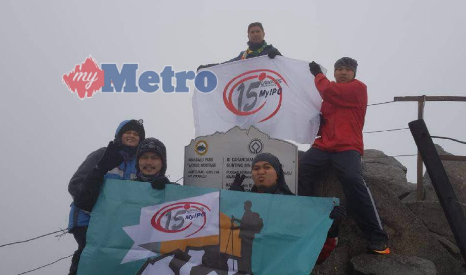 PENDAKI MyIPO mengibarkan bendera ‘MyIPO15’ di puncak Kinabalu, hari ini.