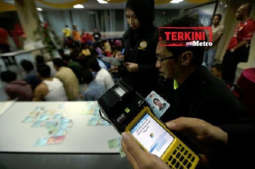 GAMBAR fail ini memaparkan Pegawai JPN dan Imigresen Pahang memeriksa sebahagian daripada kad MyKad palsu dan milik orang lain yang dirampas dalam operasi pendatang asing tanpa izin di Balok. FAIL Luqman Hakim Zubir