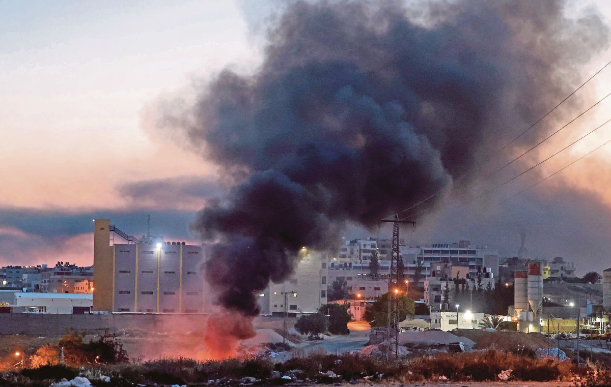 ASAP tebal dari tayar yang dibakar ketika pertempuran antara penduduk Israel dan tentera zionis di bandar Nablus. FOTO AFP 