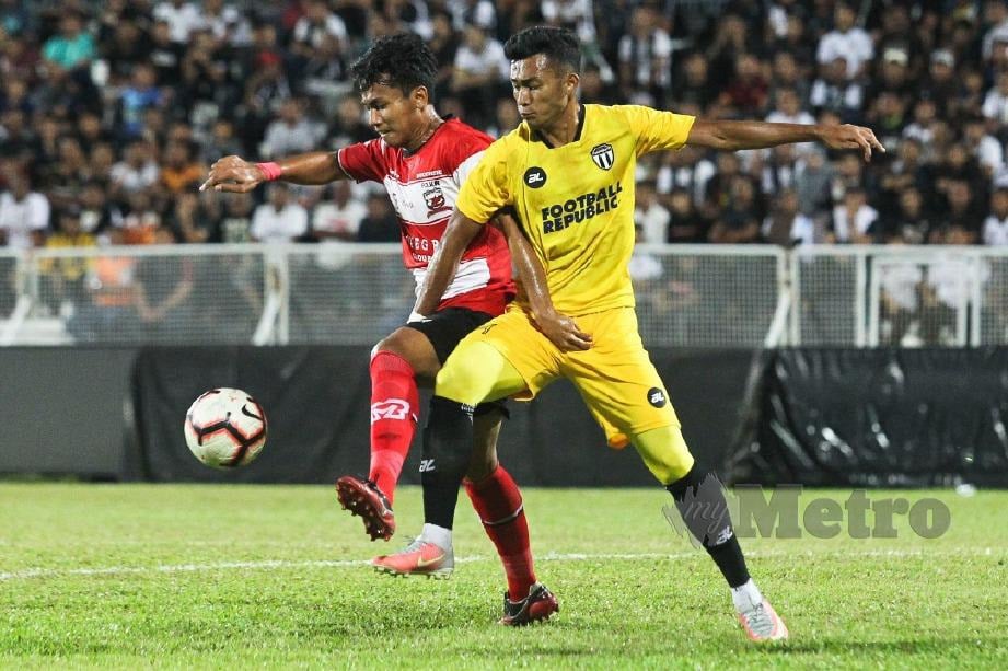 Pemain Terengganu, Engku Syakir (kanan) cuba melepasi pemain Madura United pada perlawanan persahabatan di Stadium Sultan Ismail Nasiruddin Shah. FOTO Ghazali Kori