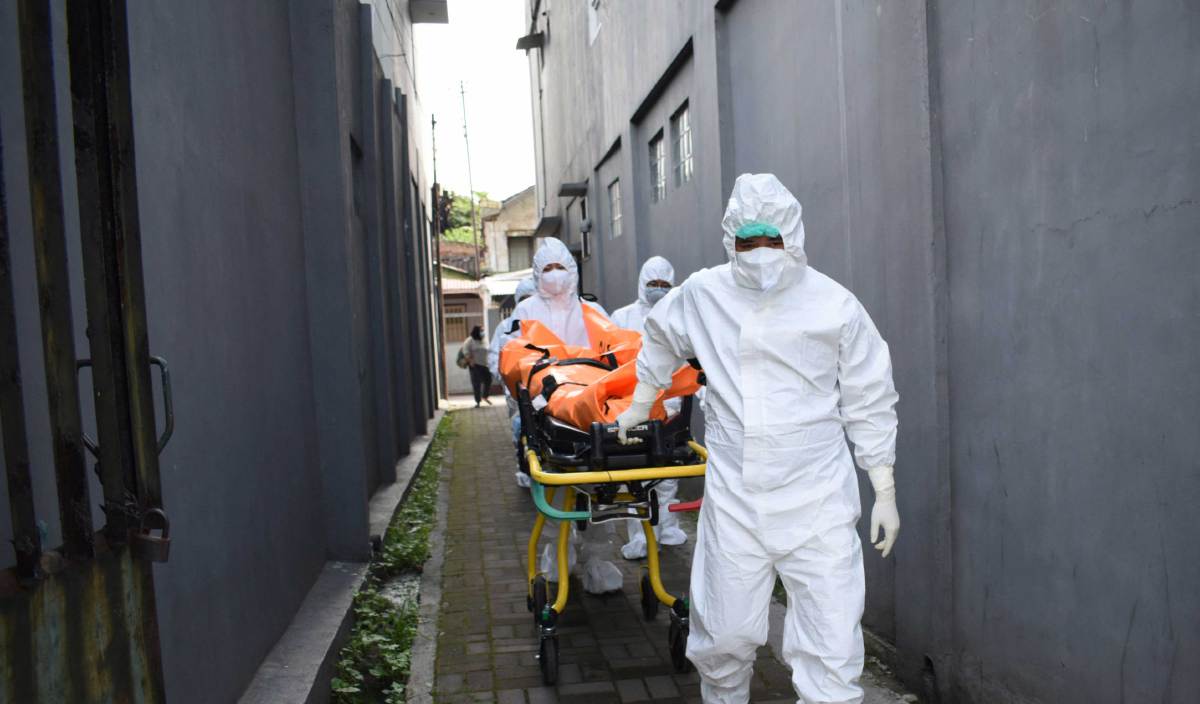 PETUGAS kesihatan membawa mangsa Covid-19 yang meninggal dunia ketika dikuarantin di rumah di Bandung. FOTO AFP