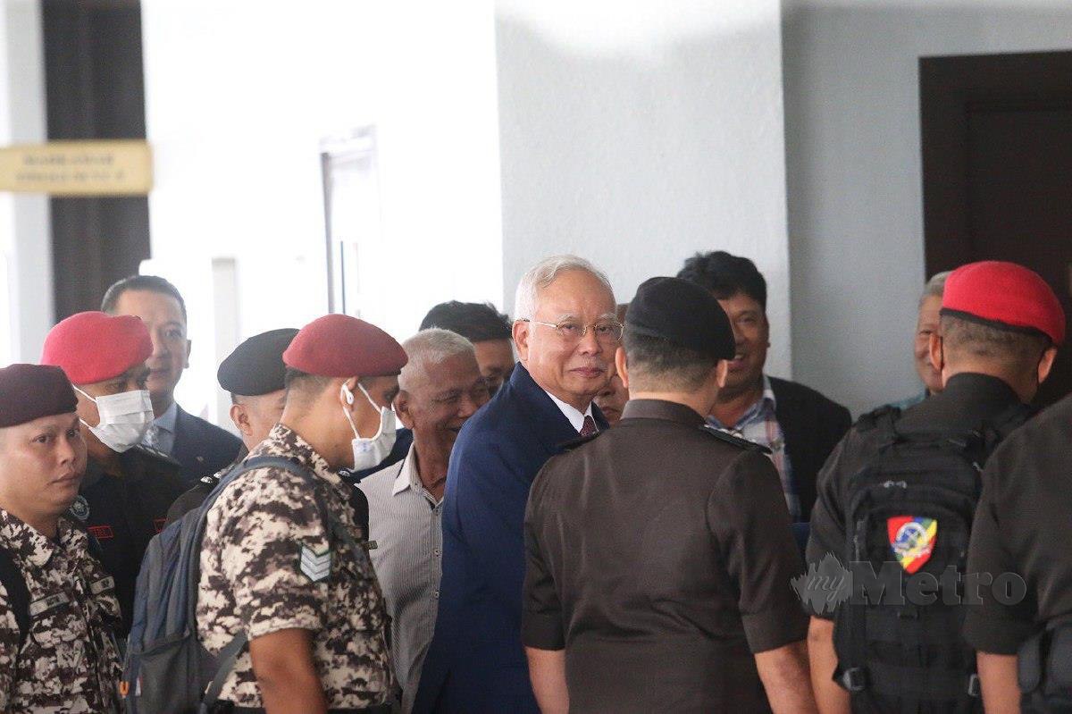 NAJIB diiringi pegawai penjara pada perbicaraan kes 1MDB di Mahkamah Tinggi Kuala Lumpur. FOTO Saifullizan Tamadi