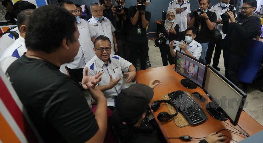 ALEXANDER mendengar penerangan dari kakitangan Les' Copaque Production Sdn Bhd semasa membuat lawatan sempena Kempen Beli Barang Malaysia (KBBM) di Seksyen 13, Shah Alam. FOTO MUHD ASYRAF SAWAL