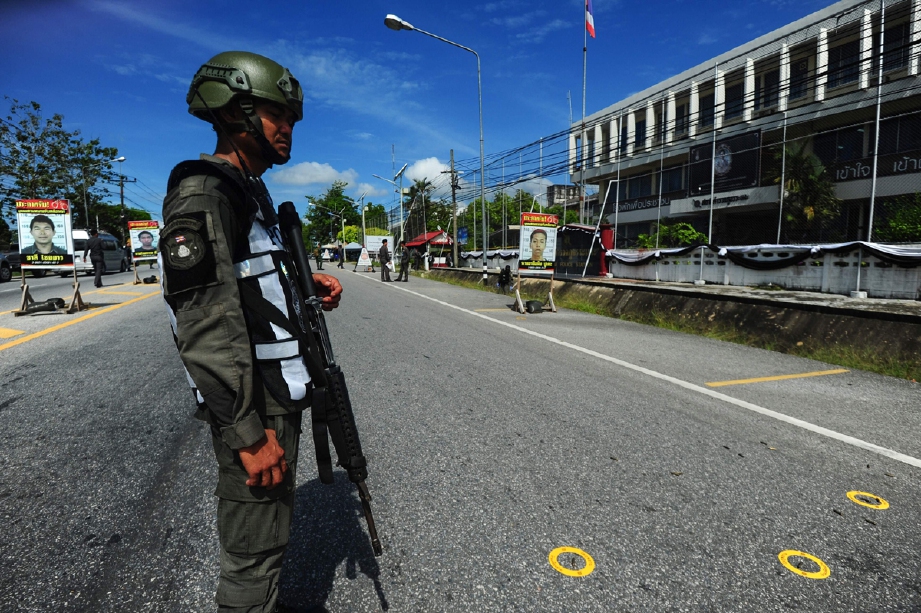Anggota tentera Thailand berkawan dekat kelongsong peluru di depan Balai Polis Ranget di Narathiwat. - Foto AP