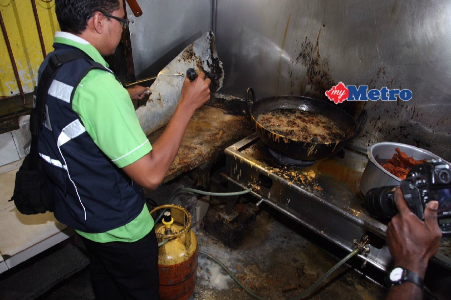 Penguat kuasa Pejabat Kesihatan Daerah Timur Laut membuat pemeriksaan di restoran nasi kandar yang kotor dan berbau. FOTO Zulaikha Zainuzman