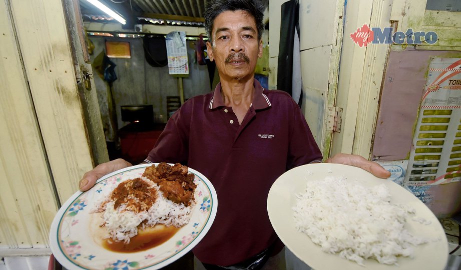 MOHD Zaki menunjukkan nasi berlauk dan nasi putih yang boleh ditambah secara percuma di kedainya. FOTO Mohd Syafiq Ridzuan Ambak