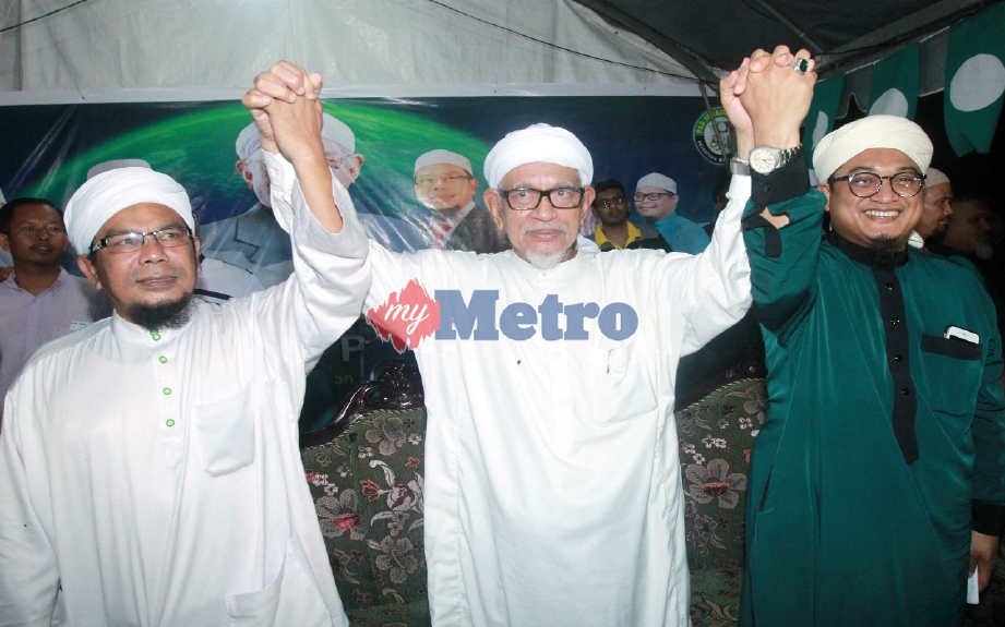 Abdul Hadi (tengah) menjulang tangan Nasrudin (kanan) dan penyandang Ahli Dewan Undangan Negeri (ADUN) Tanjung Lumpur, Rosli Abdul Jabar malam tadi. FOTO Muhd Asyraf Sawal 