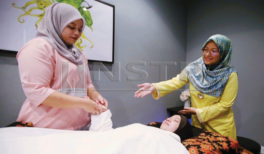 MEMBERI tunjuk ajar kepada juruterapi mengenai urutan ketika hamil. FOTO Mohd Khairul Helmy Mohd Din
