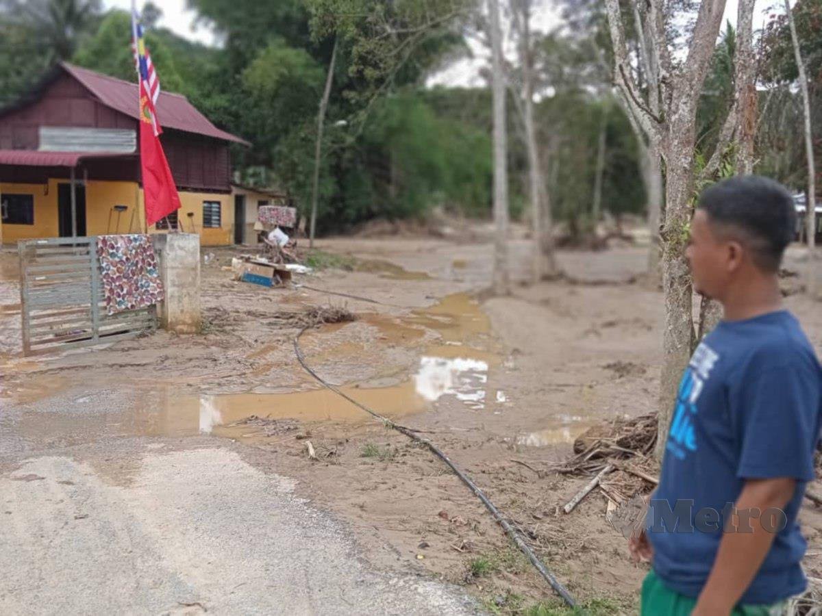 Mohd Nazrol berada di hadapan rumahnya yang dinaiki air di Kampung Padang Empang di sini, malam tadi. FOTO Noorazura Abdul Rahman