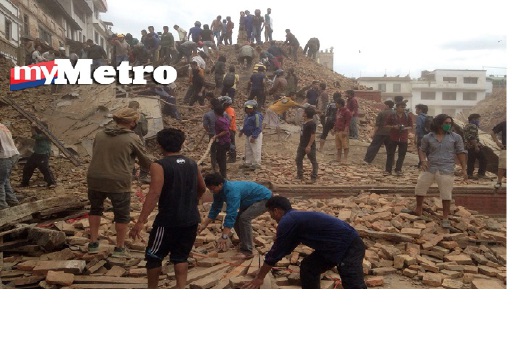 Sukarelawan membantu petugas mencari dan menyelamat di bangunan yang runtuh dalam kejadian gempa bumi di sebahagian besar Nepal, tengah hari tadi. FOTO AP 