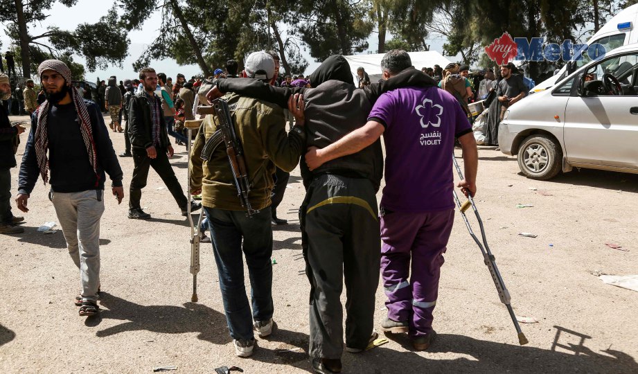  PEJUANG pemberontak Syria dan sukarelawan Violet NGO membantu seorang lelaki yang cedera. FOTO AFP