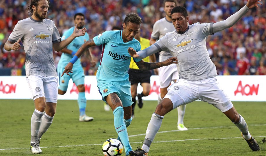 PENYERANG Barcelona Neymar (tengah) berebut bola dengan Chris Smalling ketika aksi persahabatan pramusim di Amerika Syarikat, semalam. FOTO AFP