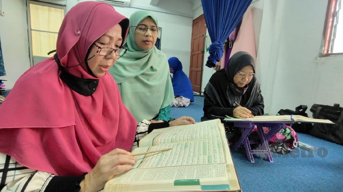 WAN Zubaidah (tengah) mengajar mualaf mengaji al-Quran. FOTO Syaherah Mustafa.