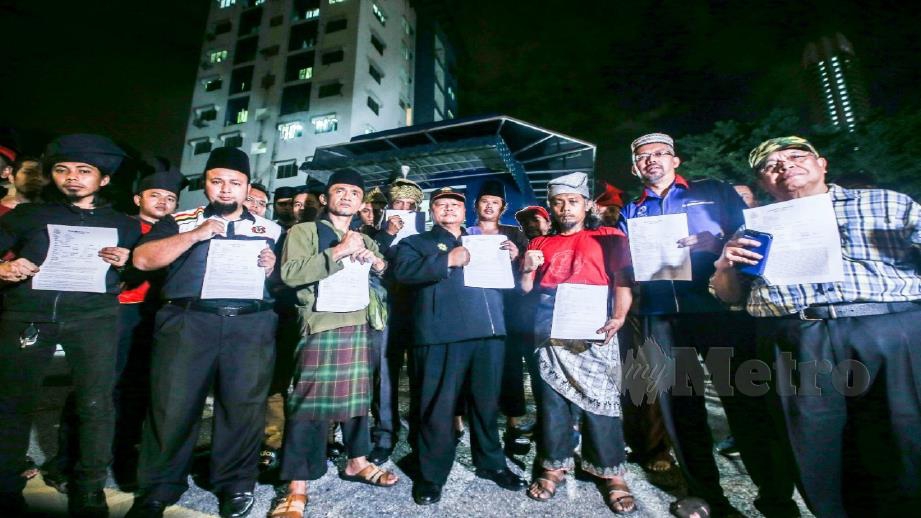 Masridzi (tengah) bersama wakil NGO yang hadir membuat laporan terhadap perhimpunan PKM di IPD Brickfields, Kuala Lumpur malam tadi. Foto Azhar Ramli 