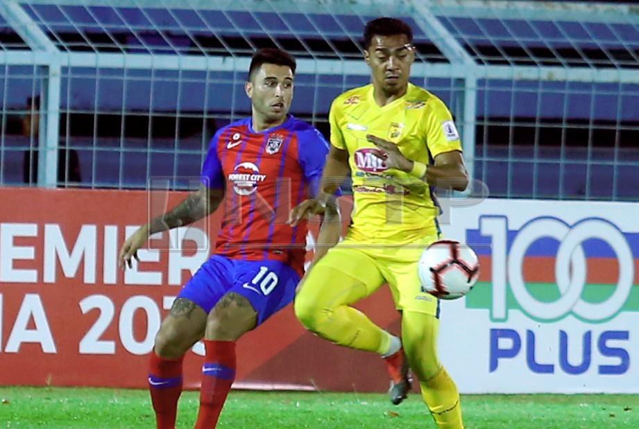 FERNANDEZ (kiri) berebut bola dengan pemain Perlis, Azmi Muslim pada perlawanan Liga Perdana di Stadium Pasir Gudang, malam ini. - FOTO Hairul Anuar Rahim